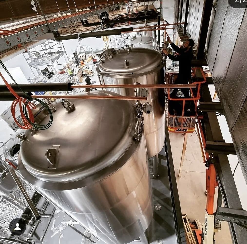 Standby Services technician working on glycol-chilled fermentation tanks at a brewery.