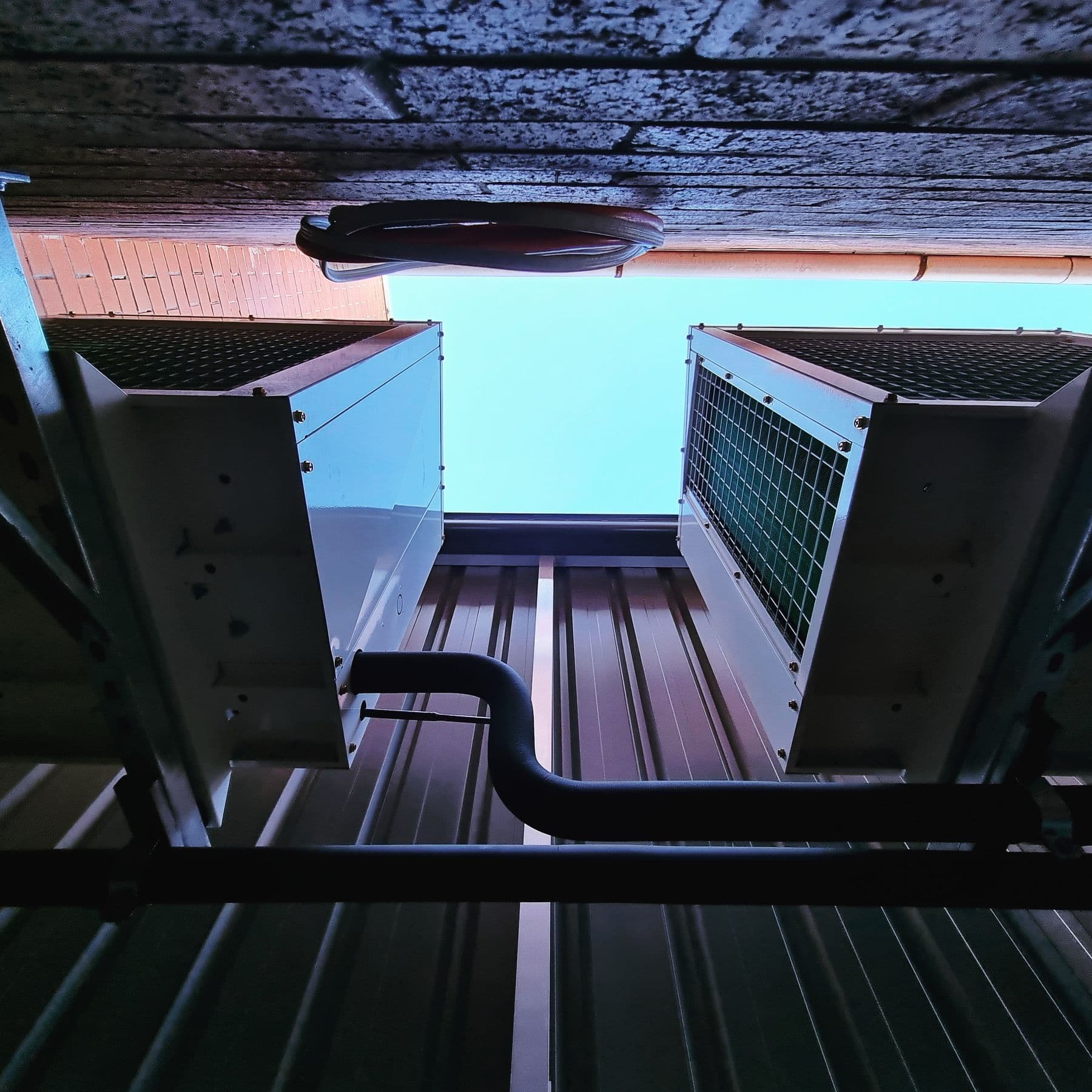Air conditioning condenser units mounted on a commercial rooftop by Standby Services.