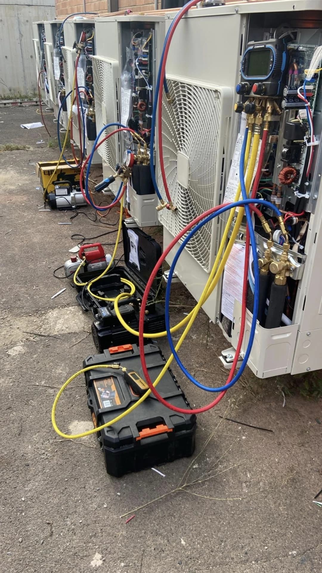 Multiple commercial air conditioning condensers connected for commissioning and service.