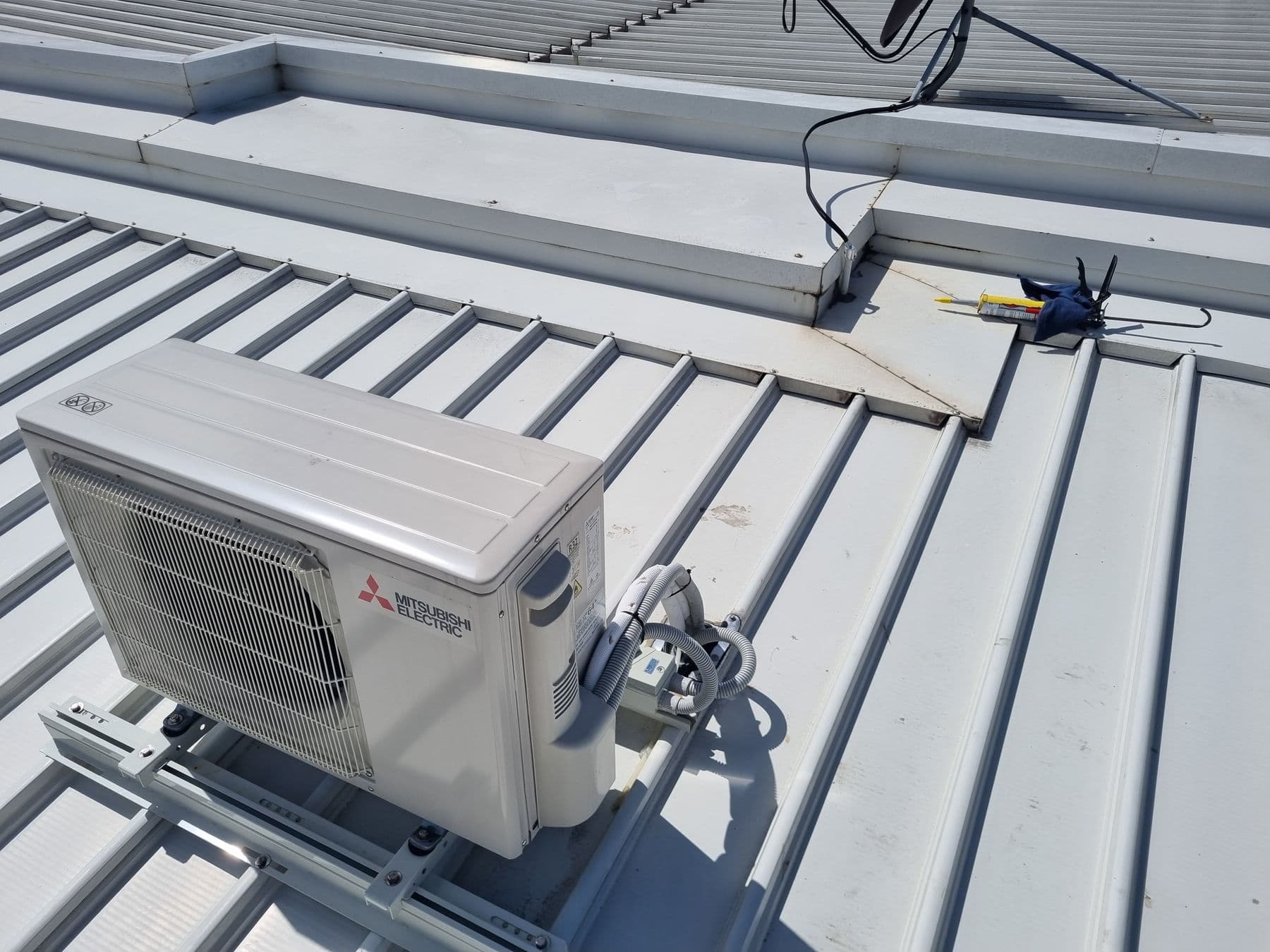 Mitsubishi Electric air conditioning condenser installed by Standby Services on a rooftop mounting frame.