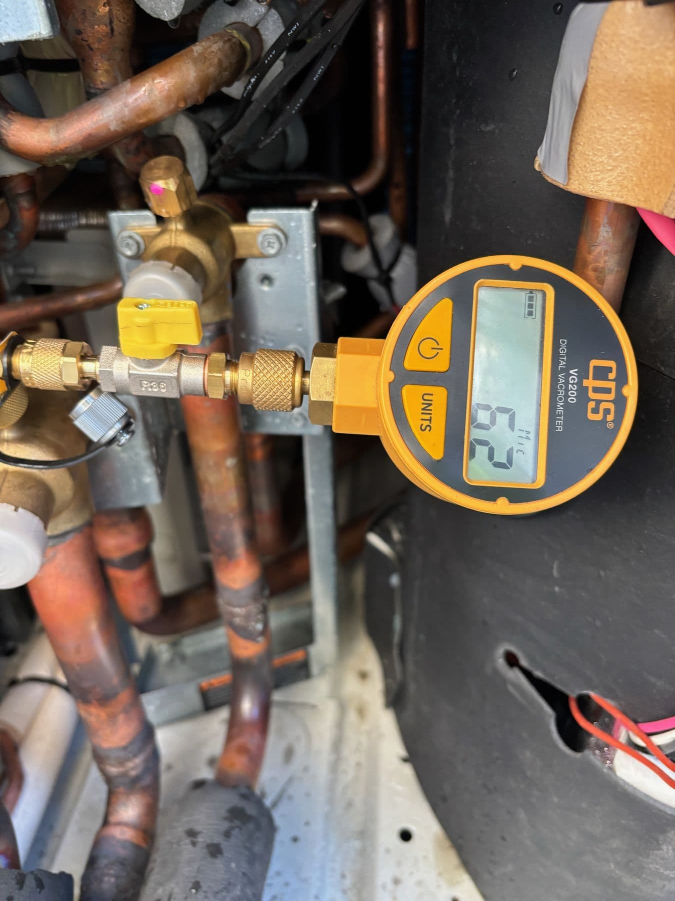 Refrigeration gauge reading pressures on a commercial system during a Standby Services breakdown call.