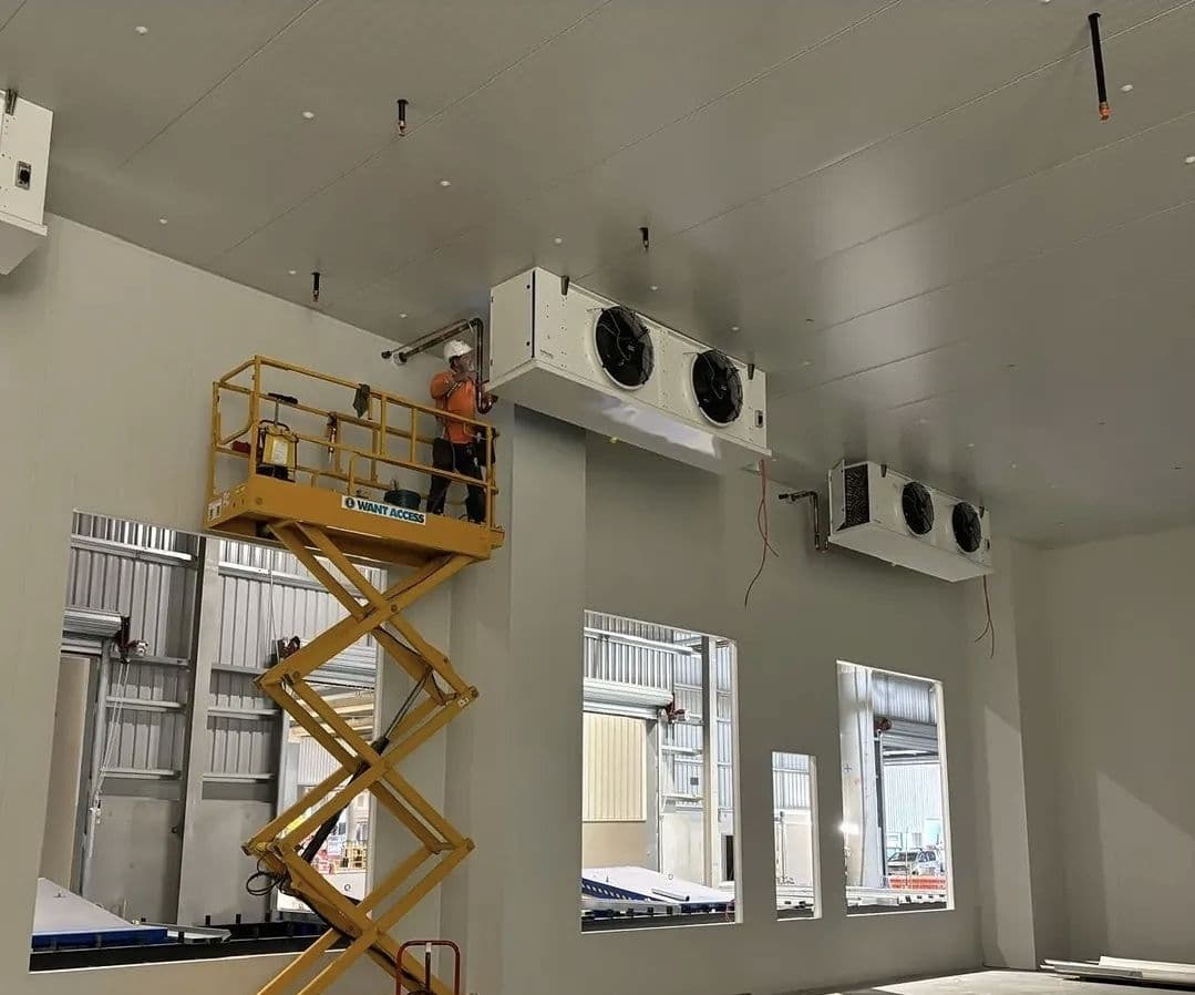 Standby Services technician in hi-vis on an elevated platform installing cool room evaporators.